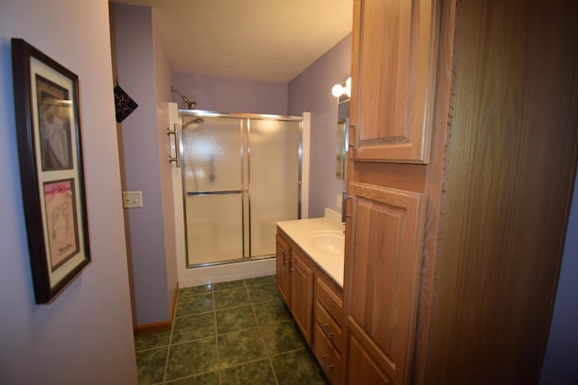 bathroom with tile patterned flooring, vanity, and walk in shower