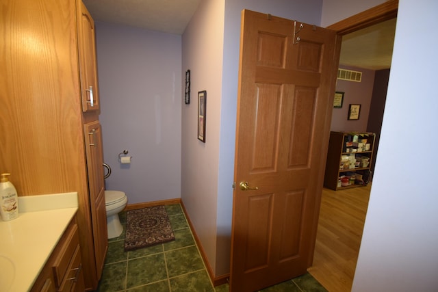 bathroom with wood-type flooring, vanity, and toilet