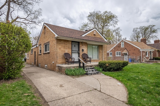 view of front of house with covered porch and a front lawn