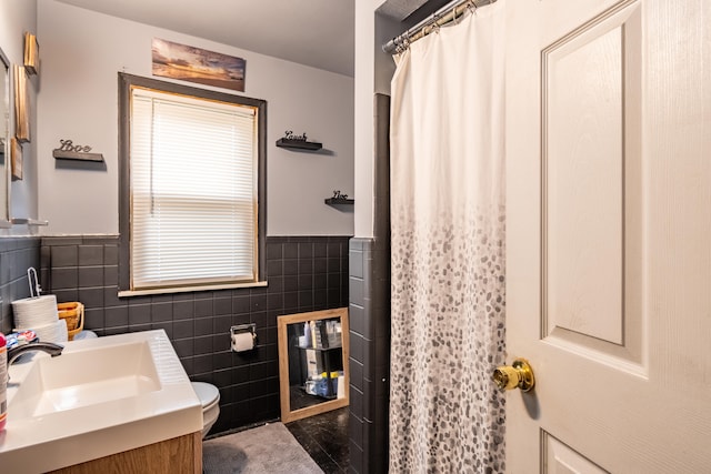 bathroom with vanity, a shower with shower curtain, tile walls, and toilet