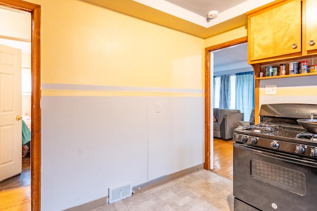 kitchen featuring black gas range and light hardwood / wood-style flooring