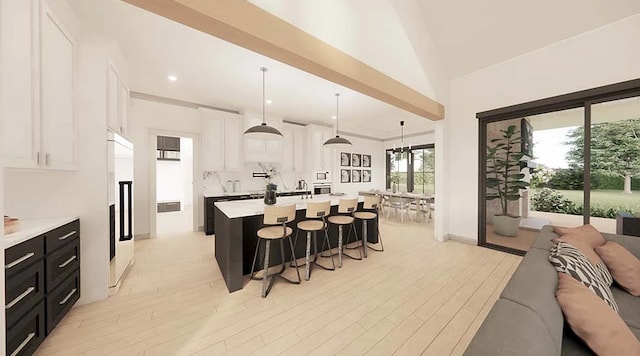 kitchen with a breakfast bar, a center island with sink, light hardwood / wood-style flooring, decorative light fixtures, and white cabinetry