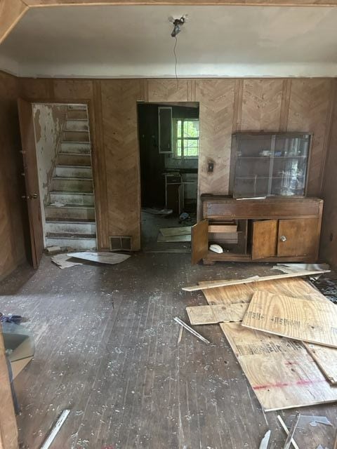 miscellaneous room featuring dark wood-type flooring and wooden walls