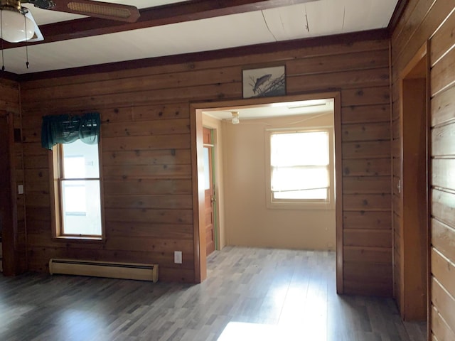 412 N Darling Ave, Fremont, MI 49412 - empty room with baseboard heating, wood walls, wood finished floors, and a ceiling fan