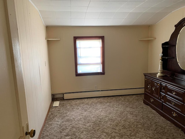 unfurnished bedroom featuring baseboard heating and light carpet