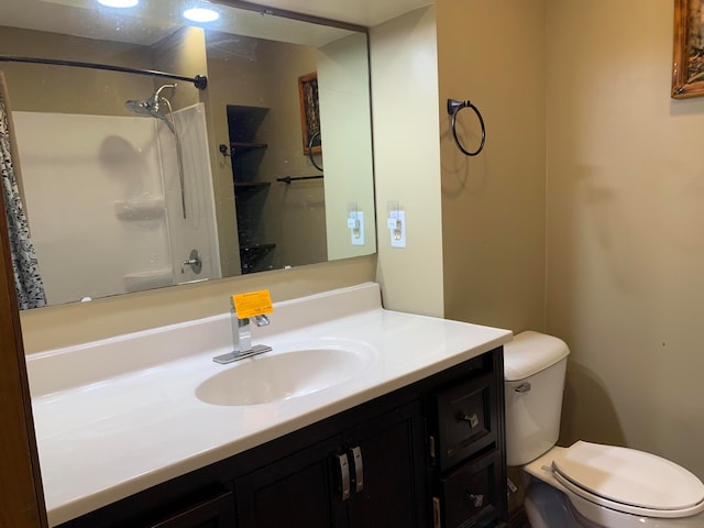 bathroom featuring a shower, vanity, and toilet