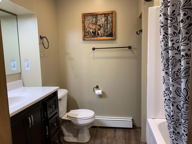 412 N Darling Ave, Fremont, MI 49412 - bathroom with a baseboard heating unit, wood finished floors, vanity, toilet, and shower / tub combo with curtain