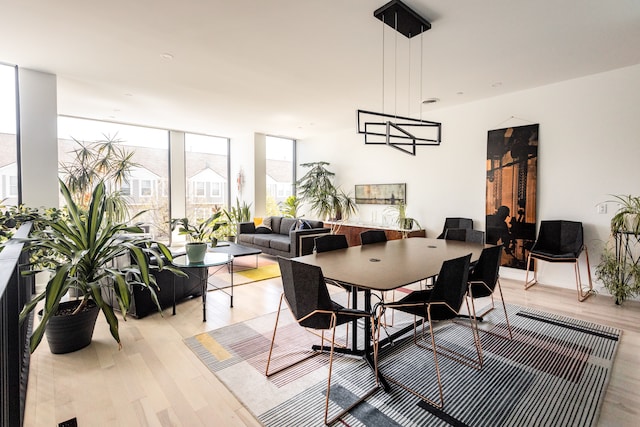 dining space featuring floor to ceiling windows and light wood-type flooring