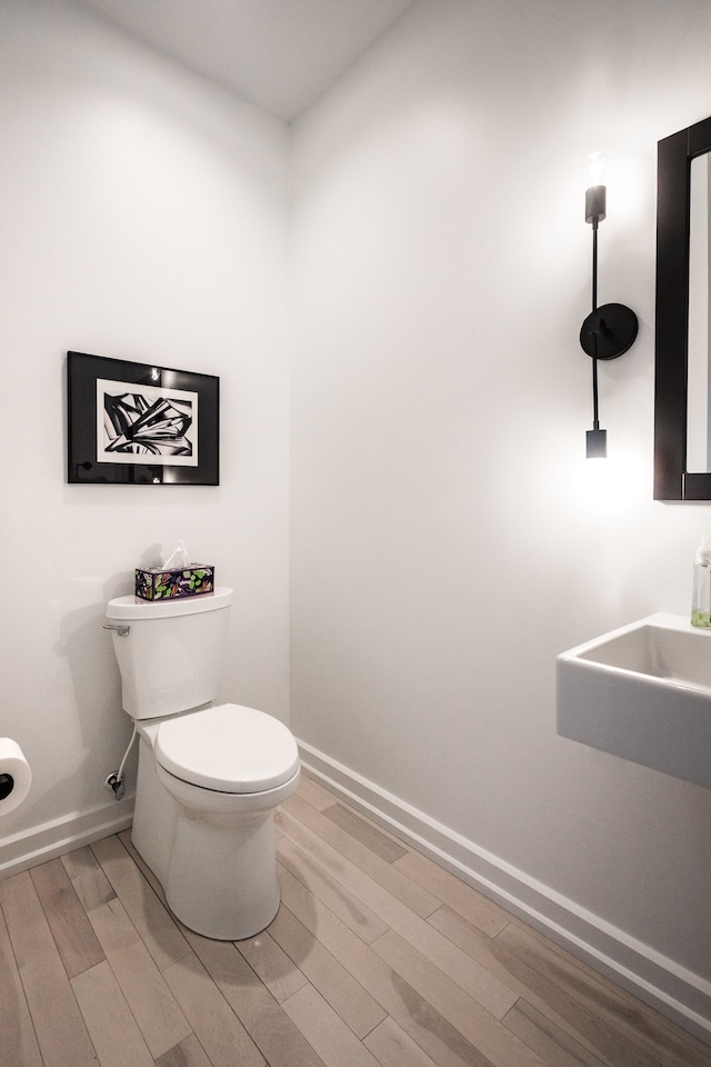 bathroom featuring hardwood / wood-style floors, toilet, and sink