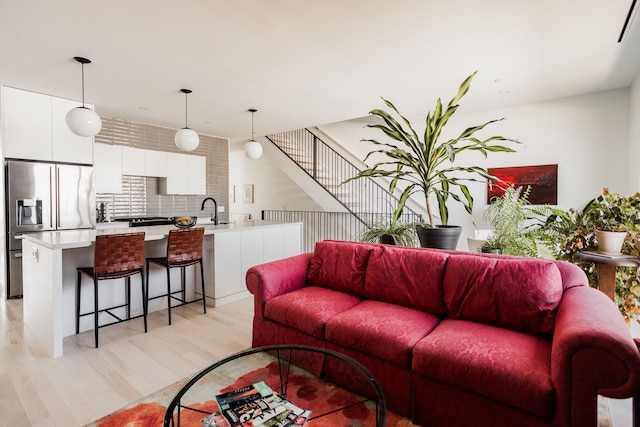 living room with light hardwood / wood-style flooring and sink