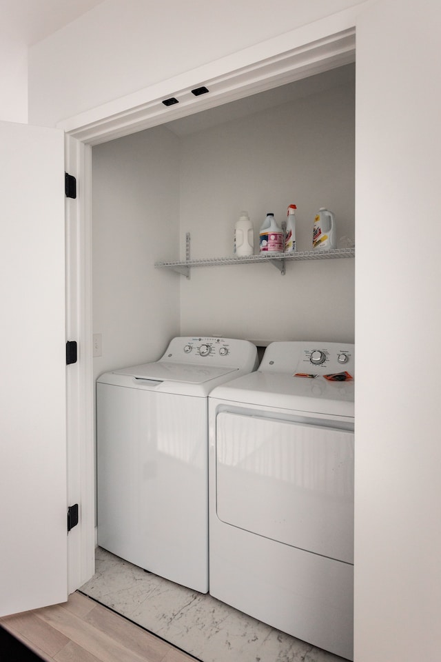 laundry room featuring washer and dryer and light wood-type flooring