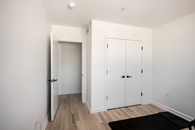 unfurnished bedroom featuring light hardwood / wood-style floors and a closet