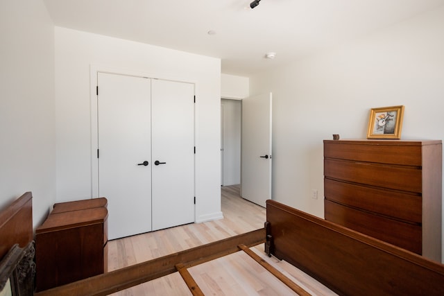 bedroom with light hardwood / wood-style floors and a closet