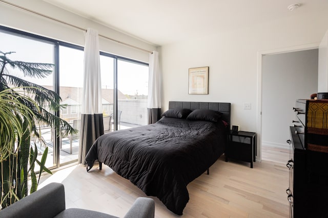 bedroom with access to exterior and light wood-type flooring