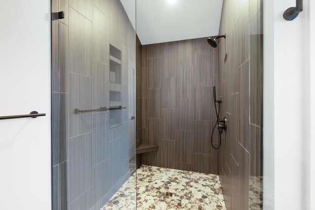 bathroom featuring a textured ceiling and tiled shower