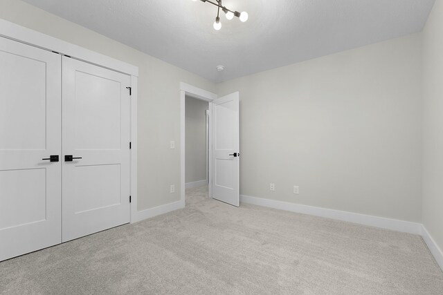 unfurnished bedroom featuring a closet and light carpet