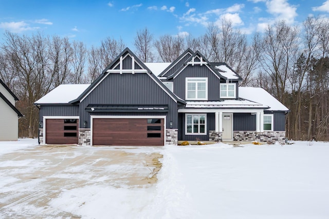 view of front facade featuring board and batten siding, stone siding, and an attached garage