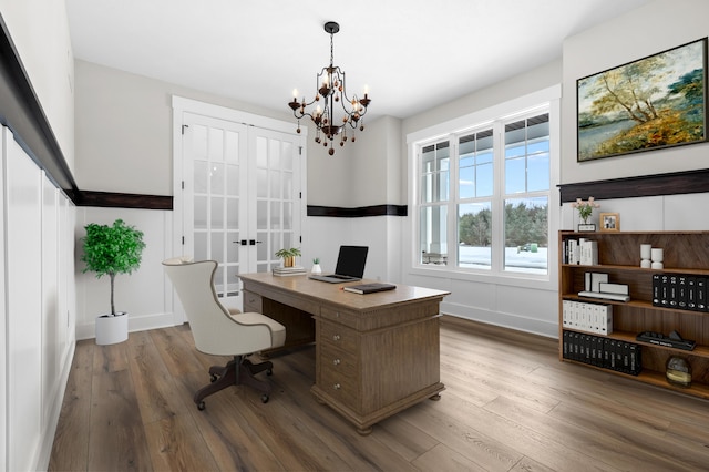 office featuring french doors, a notable chandelier, baseboards, and wood finished floors