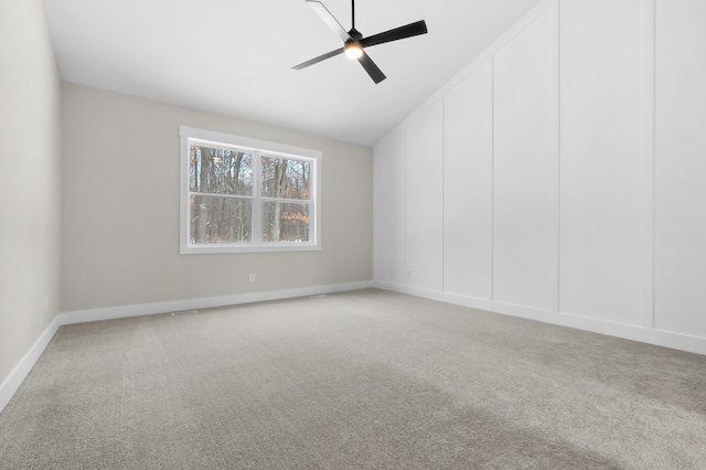 carpeted empty room featuring vaulted ceiling and a ceiling fan