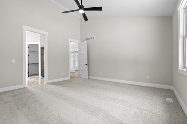 unfurnished bedroom featuring a spacious closet, carpet, visible vents, and baseboards