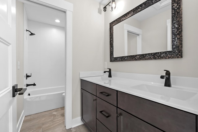 full bath featuring double vanity, tub / shower combination, a sink, and toilet