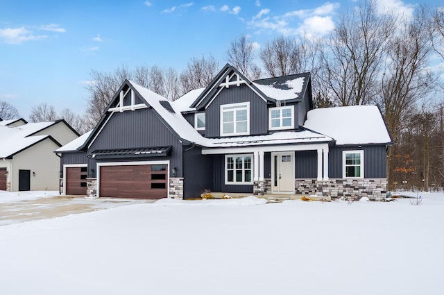 view of front of home with a garage, stone siding, metal roof, and board and batten siding