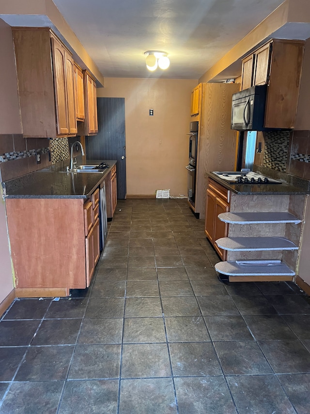 kitchen featuring backsplash, white gas cooktop, sink, and black double oven