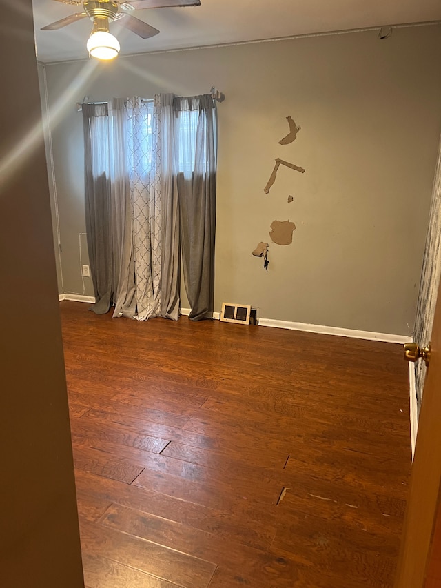 unfurnished room with dark hardwood / wood-style flooring and ceiling fan