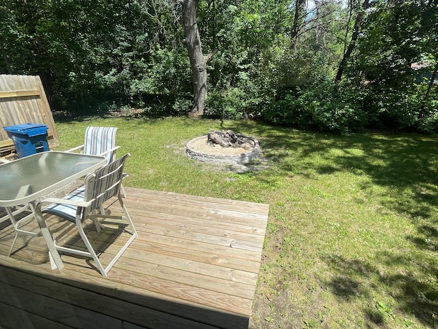 wooden terrace with a lawn and an outdoor fire pit