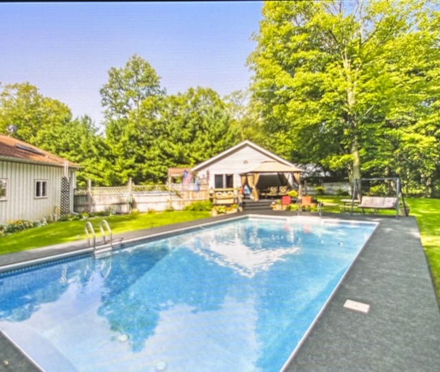 view of swimming pool featuring an outbuilding and a yard