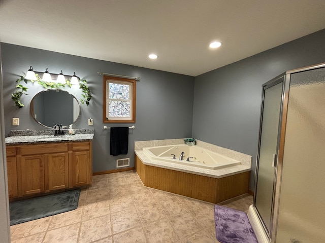 bathroom featuring vanity and independent shower and bath