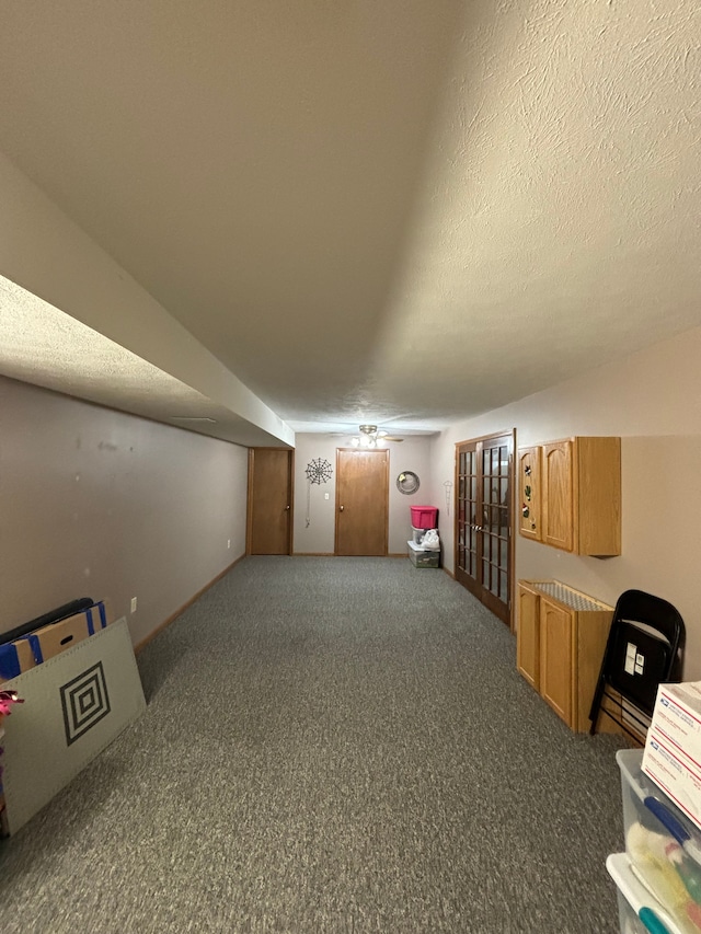 bonus room featuring dark carpet and a textured ceiling