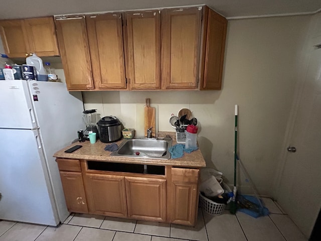 kitchen with sink, white fridge, and light tile patterned floors