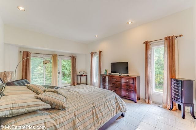 bedroom with multiple windows and light tile patterned floors