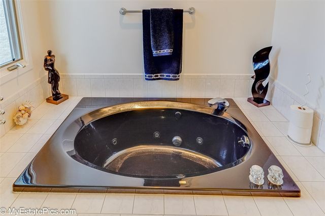 details featuring a relaxing tiled tub