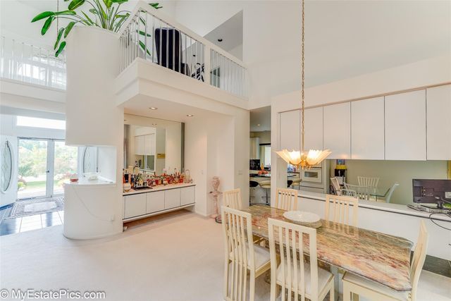 dining area featuring a towering ceiling and an inviting chandelier