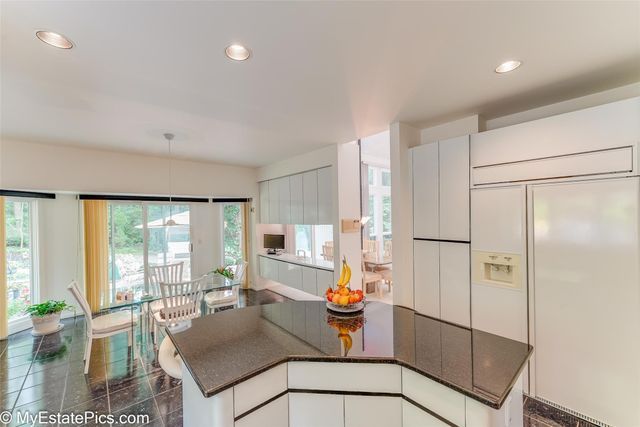 kitchen featuring white cabinetry, hanging light fixtures, and paneled refrigerator