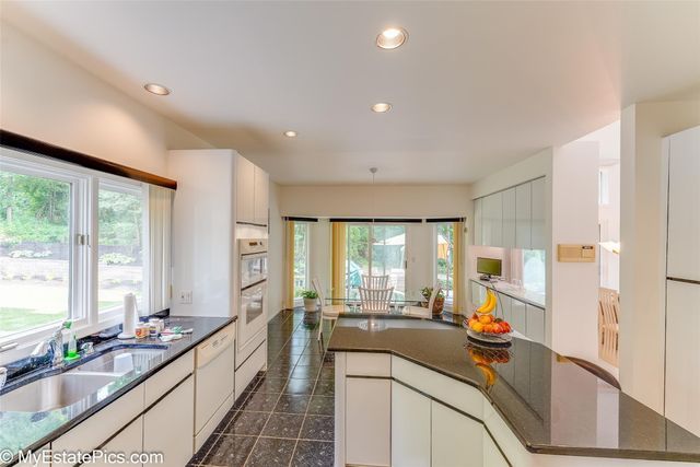 kitchen with dishwasher, white cabinetry, and sink