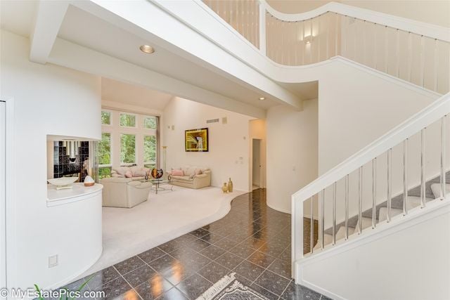 living room featuring beam ceiling and a high ceiling