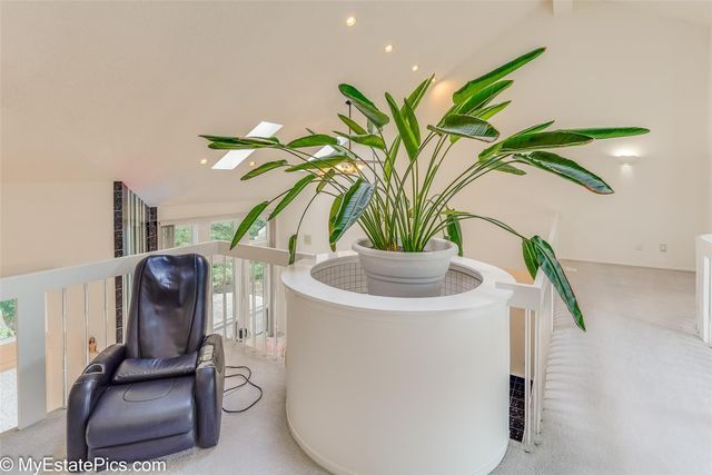 living area with light colored carpet and vaulted ceiling