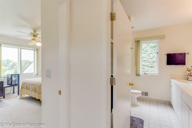 bathroom featuring tile patterned flooring, vanity, toilet, and ceiling fan