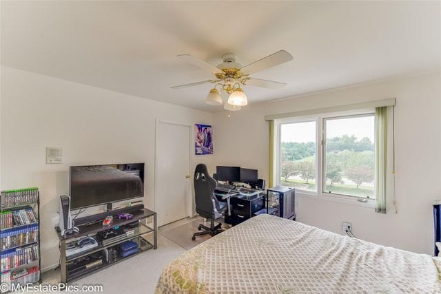 bedroom featuring light colored carpet and ceiling fan