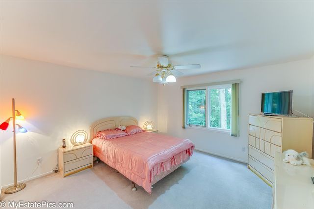 bedroom featuring ceiling fan and light carpet