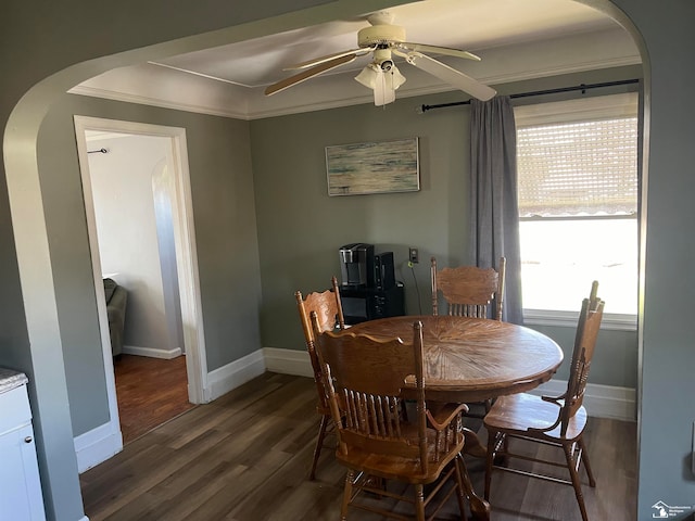 dining room featuring dark hardwood / wood-style flooring, ceiling fan, and crown molding