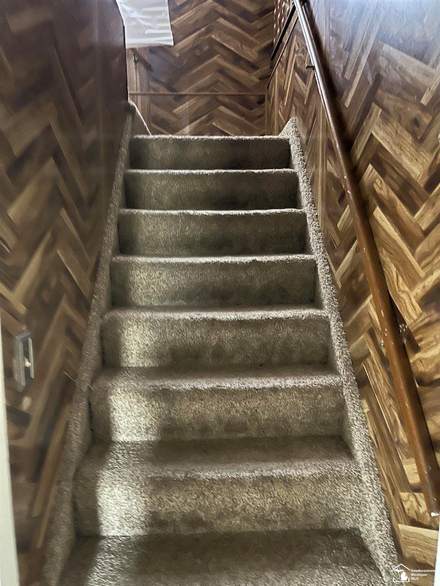 stairs featuring parquet flooring