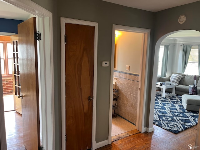 hallway featuring tile walls and hardwood / wood-style flooring