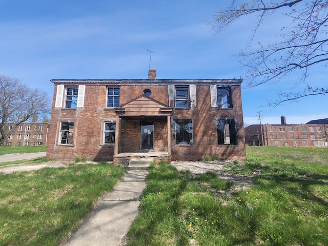 view of front of house with brick siding and a chimney