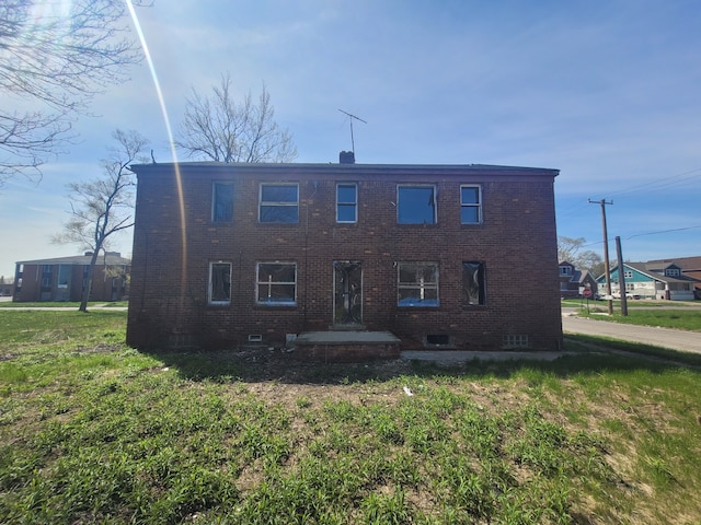 view of front of home featuring crawl space, brick siding, and a front lawn