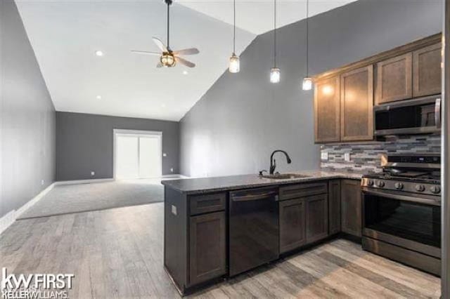 kitchen with high vaulted ceiling, sink, ceiling fan, kitchen peninsula, and stainless steel appliances