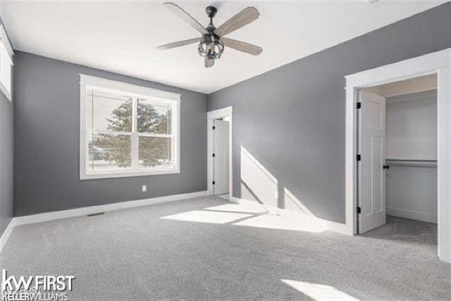 unfurnished bedroom featuring ceiling fan, light colored carpet, and a closet